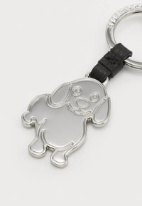 Silver dog-shaped keychain made of metal, featuring a black leather strap. Smooth surface with outline details and a smiling expression.