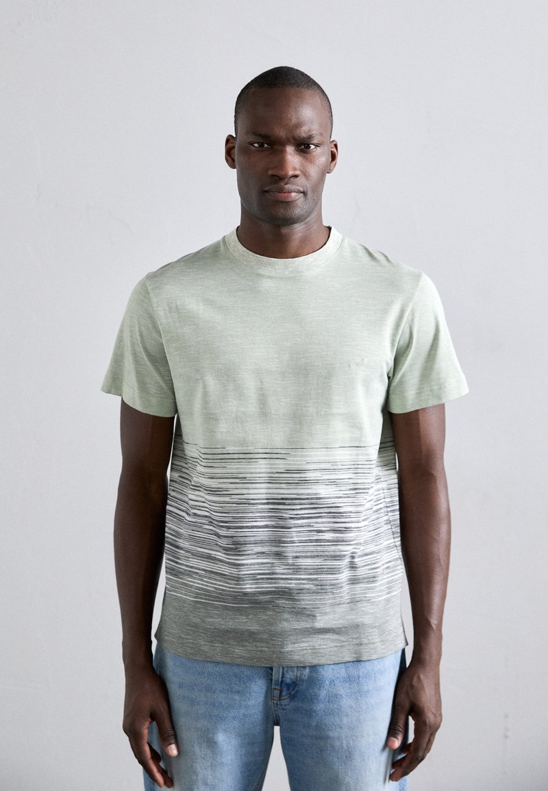 Lys grønn kortermet t-skjorte med en teksturert øvre del og et gradientstripes mønster i mørkere farger nederst.
