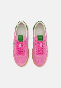 Růžové semišové tenisky se zelenými doplňky, plochými tkaničkami a podrážkou z gumy. Mají měkkou vnitřní podšívku a zaoblenou špičku.