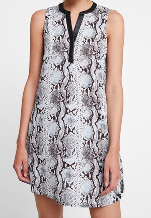 Robe sans manches avec un motif reptilian, ornée de bordures noires le long de l'encolure et de la patte de boutonnage, dans des teintes de blanc, gris et marron.