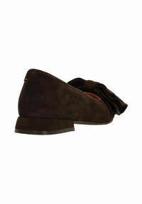Bruine suede schoen met een ronde neus, lage hak en een grote strikaccent aan de voorkant. De textuur is zacht met een gladde afwerking.