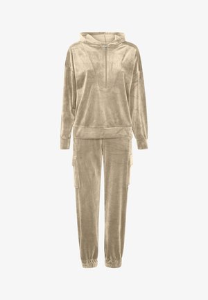 Beige bársonyos tréningruha, cipzáras kapucnival és zsebes cargo stílusú nadrággal. Puha tapintású és laza szabású, alkalmas hétköznapi viseletre.