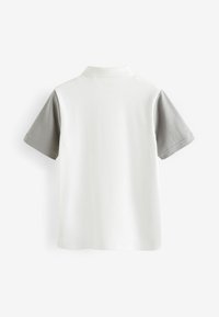 Polo blanc avec des manches courtes gris. Caractérisé par un col classique et des ourlets cousus. Le matériau semble lisse avec une coupe classique.