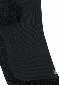 Calzino nero con texture a costine, area della caviglia imbottita, tallone rinforzato e dettaglio logo discreto nel tessuto.