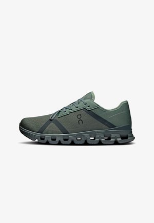 Chaussure de sport verte avec tige en mesh, finition texturée, bandes plus foncées contrastantes et semelle rembourrée avec un design segmenté distinct.