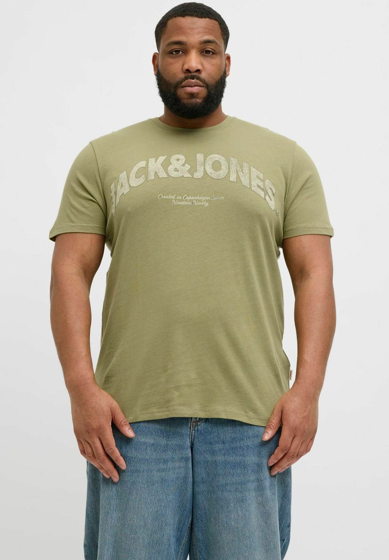 Olivgrünes Baumwoll-T-Shirt mit "JACK & JONES" in fetten, hellen Buchstaben bedruckt. Kurze Ärmel, Rundhalsausschnitt, glatte Textur, lockere Passform.
