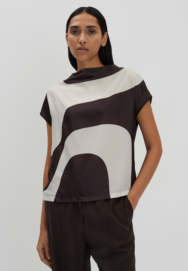 Top a maniche corte in tessuto liscio con un motivo geometrico nei toni del marrone e della crema, con colletto alto e vestibilità comoda.