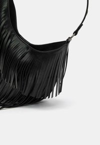 Fekete bőr táska hosszú fröccsöntött rojtokkal, ívelt formával és vállpánttal, sima textúrával és tiszta élekkel.