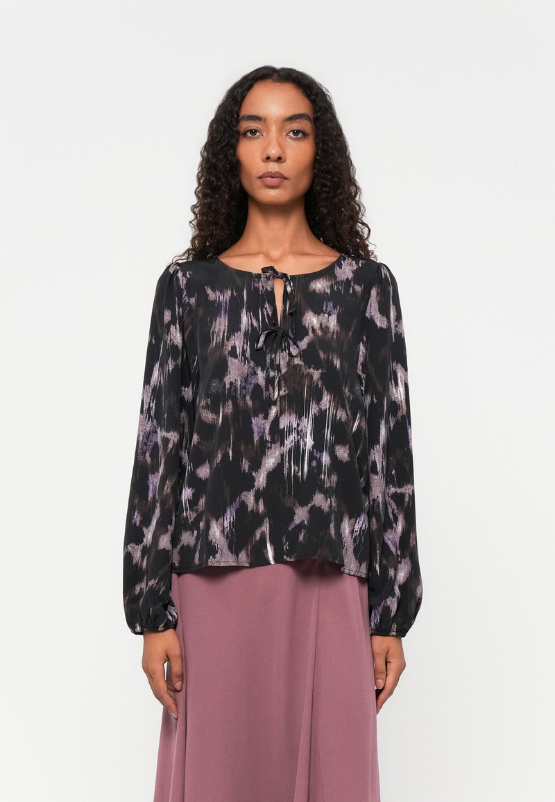 Schwarze Bluse mit lila und grauem abstraktem Muster, runder Ausschnitt, Bindedetail in der Mitte und langen Ballonärmeln, aus leichtem Material gefertigt.
