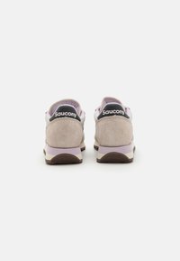 Svetlofialové a béžové semišové tenisky s bielou strednou podrážkou a svetlohnedou podrážkou, s čiernym logom "Saucony" na päte.