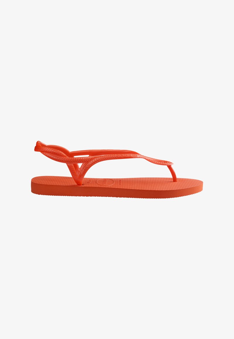 Sandale plate en caoutchouc orange avec semelle texturée et fines lanières tressées formant un entre-doigts et un maintien de la cheville.