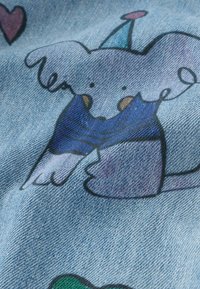 Svijetloplavi traper sadrži ručno nacrtanog slona u karikaturastom stilu, u plavoj majici, s rogačem za zabavu, okruženog šarenim srcima.
