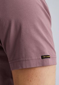T-shirt kratkih rukava u lavandi, izrađen od pamuka s glatkom teksturom. Ima crnu PME Legend oznaku na rubu za brendiranje.