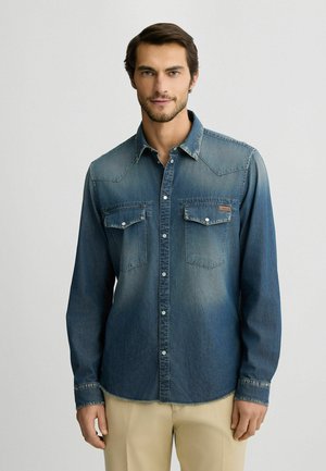 Denim shirt, dark blue gradient, long sleeves, snap-flap pockets, pointed collar, button front, slightly faded texture, casual design.