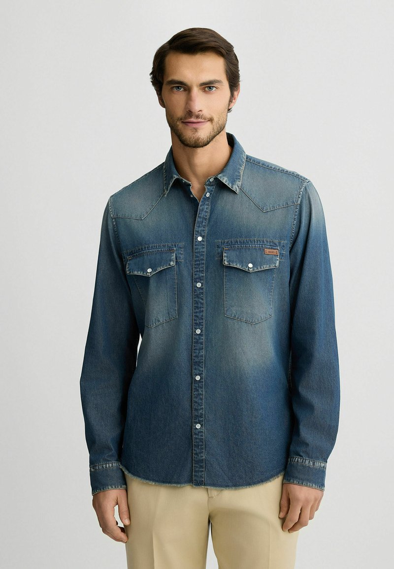 Jeans srajca, temno modra gradient, dolgi rokavi, žepi s nastavitvami, konični ovratnik, sprednji gumb, nekoliko zbledela tekstura, sproščen dizajn.