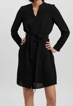 Sort, langærmet kjole lavet af glat stof med knapper foran, krave og et bindebånd i taljen. Struktureret design i knælængde.