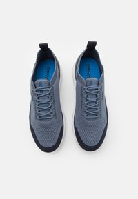 Zapatillas deportivas transpirables grises con parte superior texturizada, detalles en azul marino, cordones planos y suela blanca acolchada. Marca Geox visible en la lengüeta.