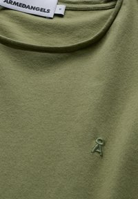 Olijfgroen katoenen T-shirt met een ronde hals en een gestructureerde afwerking; heeft een klein, geborduurd lintlogo in dezelfde kleur.