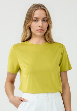 Korte mouwen, ronde hals T-shirt in felgroen, gemaakt van zachte stof, met een relaxte pasvorm en minimale naden voor comfort.