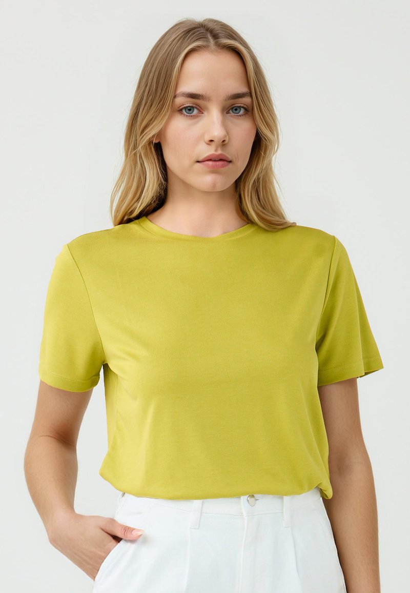 T-shirt a maniche corte, collo tondo di colore verde brillante realizzato in tessuto morbido, con una vestibilità comoda e cuciture minime per maggiore comfort.