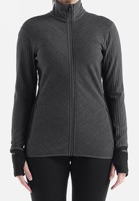 Chaqueta de cremallera, de manga larga, en tejido gris carbón con mangas acanaladas texturizadas, orificios para los pulgares y bolsillos laterales con cremallera. Diseño de cuello abierto.