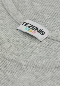 Szara materiał z prążkami z okrągłym dekoltem. Metka z napisem "TEZENiS KIDS" w kolorowych literach, podkreślająca markę i rodzaj produktu.