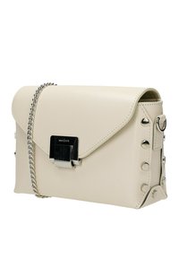 Beige faux leren handtas met een klep-sluiting, zilveren hardware, kettingband en studaccenten langs de zijkant voor extra detail.