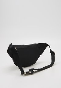 Black waist bag made of durable fabric; features a zippered compartment, adjustable strap, and a textured surface for grip.