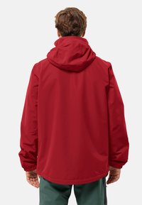 Giacca impermeabile rossa con cappuccio, polsini elasticizzati e vestibilità ampia. Texture liscia senza motivi o dettagli visibili.