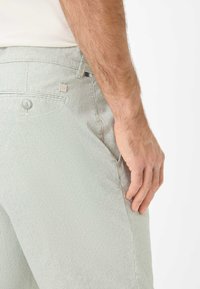Lichtgroene en witte gestreepte katoenen broek met een slim fit. Voorzien van een knoopsluiting en zijzakken, en het toont een gestructureerde stof.