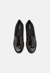 Zwarte instapper schoenen met een glanzende lakleren neus en een textiel bovenwerk. Gestikte details aan de randen, comfortabele binnenzool.