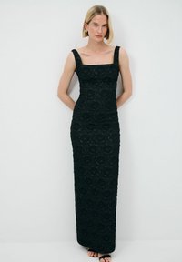 Schwarzes Spitzen-Abendkleid mit figurbetontem Design, quadratischem Ausschnitt und breiten Trägern. Bodenlang mit strukturierten Blumenmustern überall.