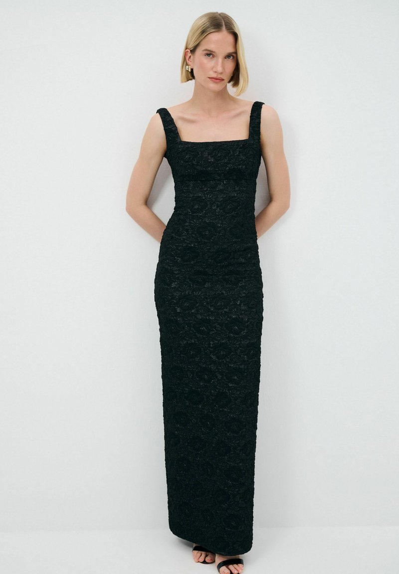 Schwarzes Spitzen-Abendkleid mit figurbetontem Design, quadratischem Ausschnitt und breiten Trägern. Bodenlang mit strukturierten Blumenmustern überall.