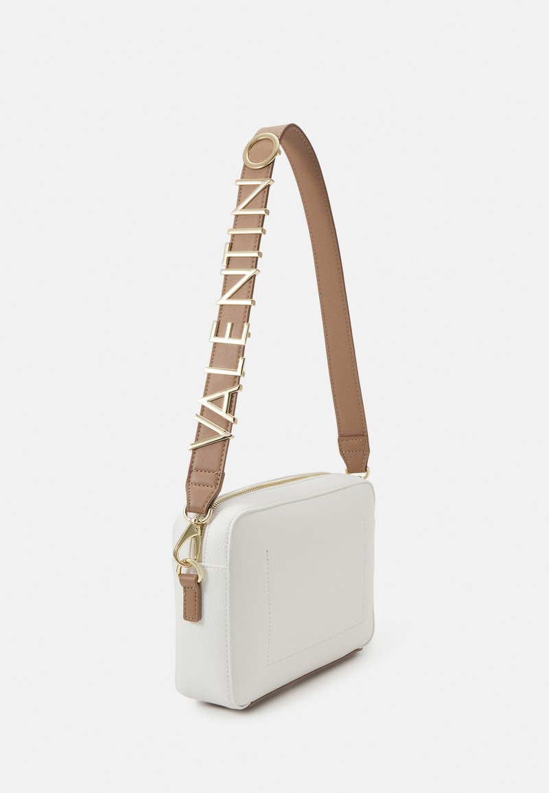 Bolso bandolera blanco de cuero con herrajes dorados y una correa marrón que presenta letras del logo en relieve. Forma cuadrada con cierre de cremallera.