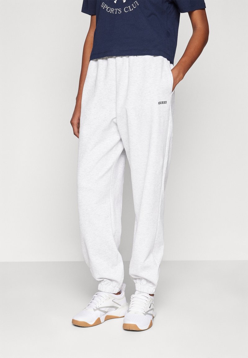 Lichtgrijze joggingbroek van katoen, met een taps toelopende pasvorm en elastische boorden. Gecombineerd met een navy cropped T-shirt en witte sneakers.