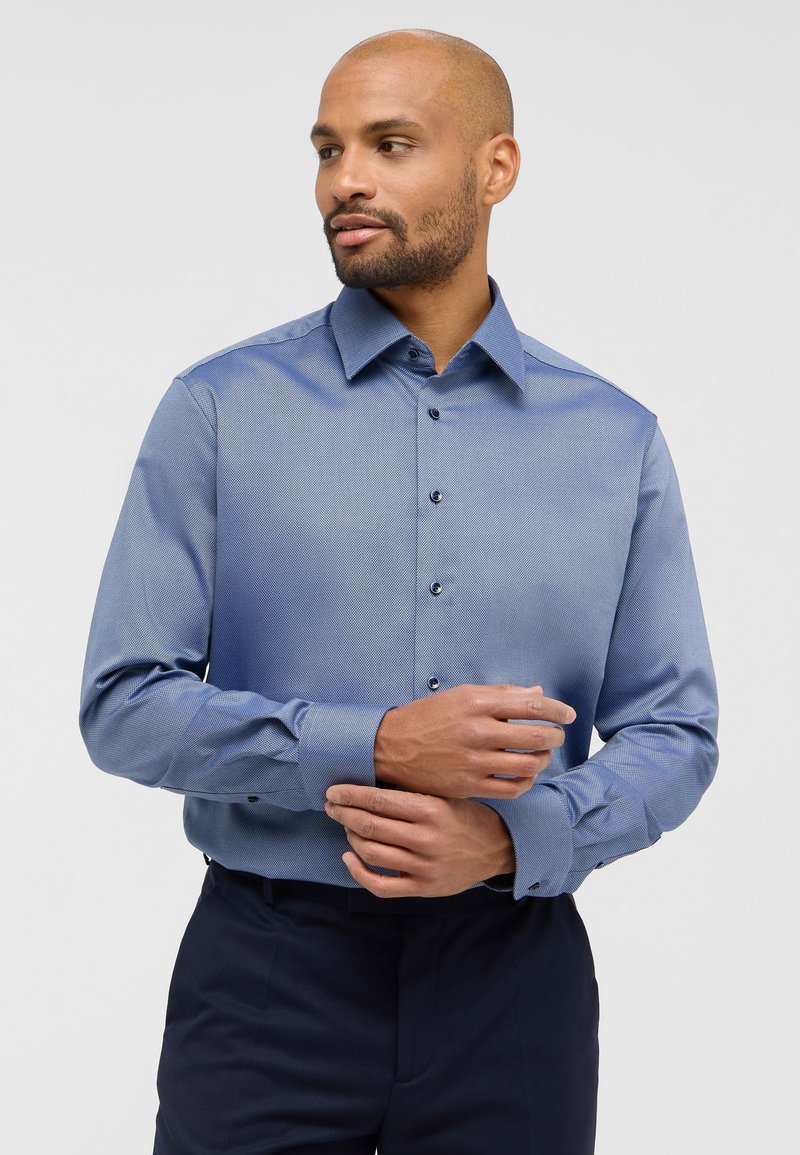 Lichtblauw dress shirt met een klein ruitpatroon, puntige kraag en knoopsluiting. Getailleerde pasvorm met lange mouwen en knoopmanchetten.