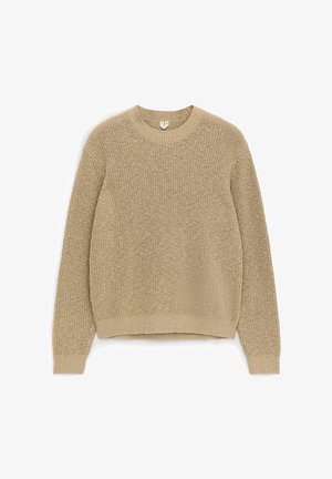 Maglione beige a girocollo lavorato a maglia con maniche lunghe, polsini e orlo a coste, posato disteso su uno sfondo bianco.