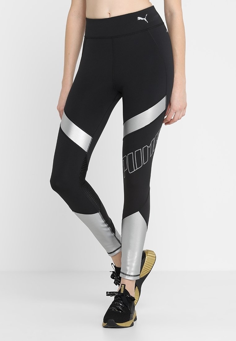 Leggings neri con dettagli argento e logo PUMA. Caratteristiche includono una vita alta e pannelli in rete per la traspirabilità.