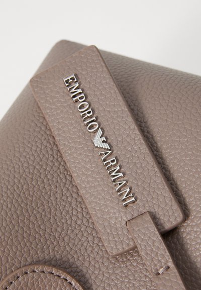 Brown textured leather handbag featuring an embossed "Emporio Armani" logo in silver hardware. Includes a rounded accent near the base.
