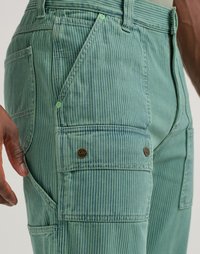 Green striped cargo pants feature multiple pockets, brown hardware accents, and a textured fabric. Includes branded detail on the left pocket.