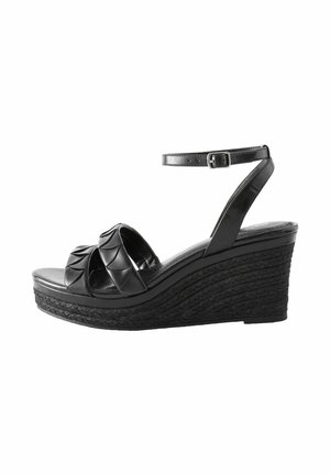 Schwarze Wedgesandalen mit einer geflochtenen Jute-Plattform, ausgestattet mit überkreuzten strukturierten Riemen und einem verstellbaren Knöchelriemen. Flacher Absatz.