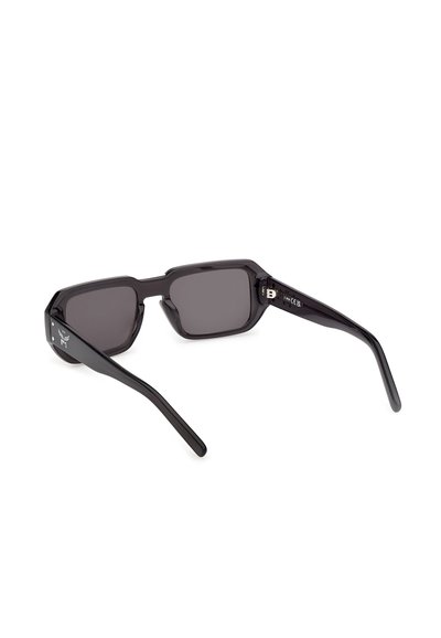 Schwarze rechteckige Sonnenbrille mit dicken Rahmen und dunkel getönten Gläsern, von hinten und leicht seitlich betrachtet.