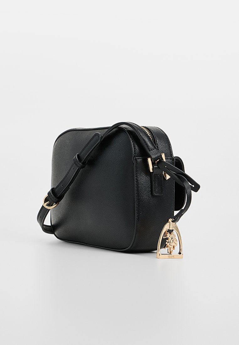 Sac en cuir noir à bandoulière avec une texture lisse, de forme rectangulaire, des accents en métal doré et un charme décoratif.