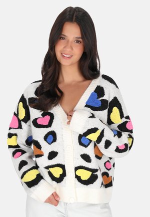 Cardigan met een witte basis, voorzien van kleurrijke hart- en luipaardprintpatronen in roze, blauw, geel en zwart. Knopen aan de voorkant, geribbelde manchetten.