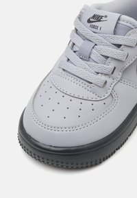 Szare skórzane sneakersy z zaokrąglonym noskiem, perforacjami na przodzie, szarymi sznurowadłami oraz czarną gumową podeszwą z bieżnikiem w kształcie gwiazdy.