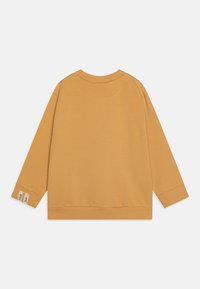 Senfgelbes Sweatshirt aus weichem Baumwollmaterial, mit Rundhalsausschnitt, langen Ärmeln, gerippten Bündchen und Saum, versehen mit einem kleinen Etikett am Bündchen.