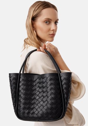 Borsa tote in pelle intrecciata nera con manici doppi, che presenta un ampio interno e una texture liscia. Il design è strutturato ma flessibile.