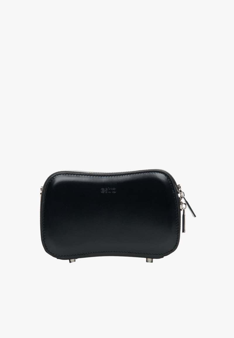 Černá kožená taštička se hladkým povrchem, zakřiveným tvarem, stříbrnými doplňky, zapínáním na horní zip a decentně embosovaným logem na přední straně.