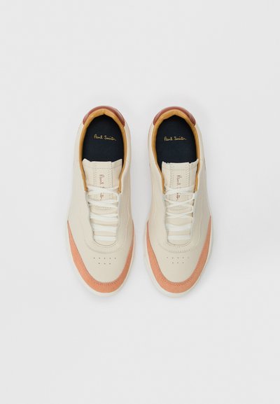 Sneaker con una parte superiore in pelle crema, dettagli in suede arancione chiaro, lacci bianchi e una soletta blu con lettering dorato.