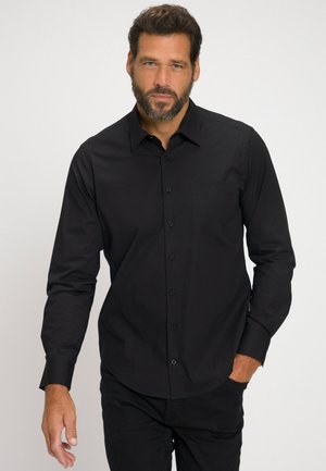 Zwarte langemouwen shirt met knopen aan de voorkant, één borstzak en een gladde textuur, gecombineerd met donkere broek. Geen zichtbare patronen of accenten.